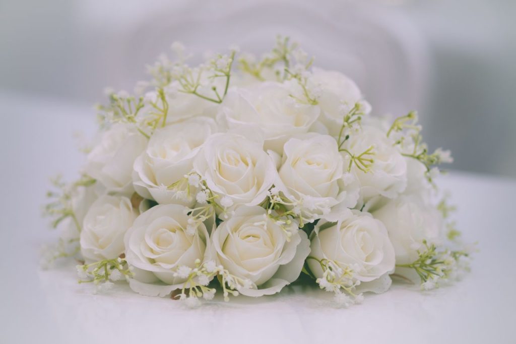 ACCUEIL Beautiful bouquet of white roses with delicate greenery, perfect for weddings or special occasions.